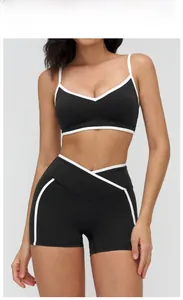 Detail of cross-over V-waist design on black sports shorts with white contrast trim