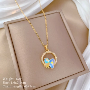 Detail view of gold butterfly pendant with iridescent finish and cubic zirconia ring