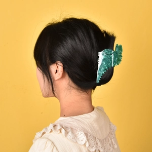 Green marble acetate hair claw clip for women shown on model with updo hairstyle