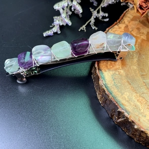 Detailed macro view of handmade crystal spring clip with fluorite stones and silver wire wrapping