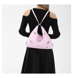 Detailed back view of pink nylon shoulder bag featuring silver butterfly ornaments