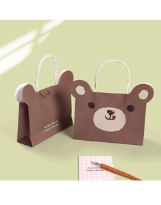 Detail view of brown bear-shaped paper gift bag with 3D ears and white handles