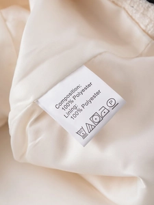 Détail de l'étiquette de lavage d'une veste de style français montrant 100% polyester