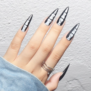 Gothic Halloween stiletto press-on nails featuring white skeleton bone patterns on black