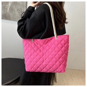 Détail du sac cabas matelassé en nylon rose avec de larges bretelles en corde blanche