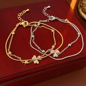 Detailaufnahme zweischichtiger Kleeblatt-Armbänder in Gold- und Silberoptik