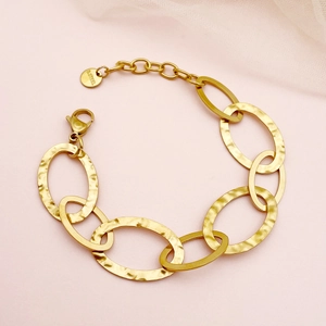 Gold plated stainless steel chunky chain bracelet with hammered oval links on pink background