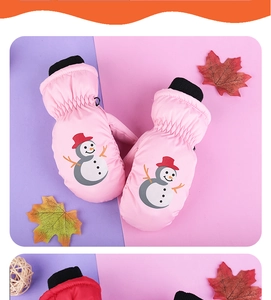 Close-up of pink waterproof ski mittens with snowman pattern and black knitted cuffs