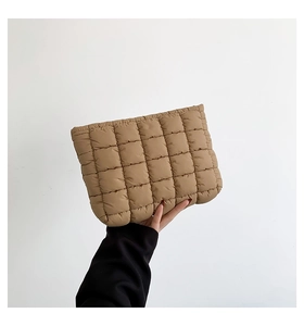 Macro detail of camel quilted down fabric on a rectangular fashionable clutch handbag
