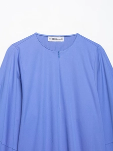 Détail de l'encolure de la chemise en popeline bleue avec fermeture éclair invisible