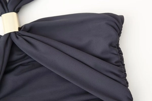 Vue détaillée de la texture du tricot foncé avec d'élégantes boucles en métal doré