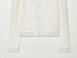 Detailed close-up of intricate lace texture and traditional Chinese frog buttons on white shirt