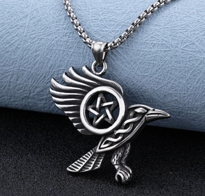 Macro shot of stainless steel eagle pendant with pentagram star and detailed wing feathers
