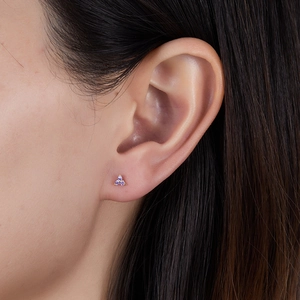 Detailed view of three purple cubic zirconia stones in a gold floral stud earring