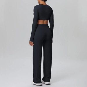 Rear view of black high-waisted wide-leg yoga pants and long-sleeve crop top athletic set