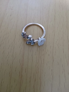 Detailed macro view of rose gold branch ring with white flower and crystal leaves