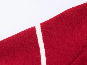 Détail du tissu tricoté rouge avec rayure blanche sur ce gilet de Noël décontracté