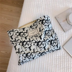 Close-up of cotton clutch with floral pattern and Time to Party woven label detail
