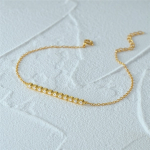 Detail of a thin gold 925 silver bracelet with small cubic zirconia stones and adjustable clasp
