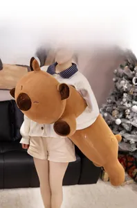 Detailed view of an extra long plush capybara body pillow in a cozy Christmas setting