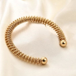 Dettaglio del bracciale a molla in oro 18K con terminali a sfera su seta elegante