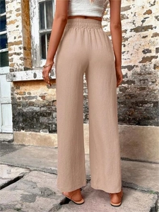 Détail du pantalon large à taille haute beige avec texture de tissu froissé naturel