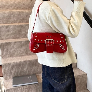 Red punk style shoulder bag with rivets and buckles in shiny patent leather finish