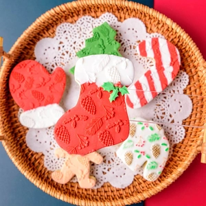 Christmas cookie cutters set with gingerbread man, tree and glove shapes in festive basket