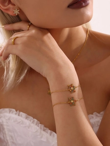 Detailaufnahme eines Schneeflocken-Schmucksets mit bunten Zirkonias auf Goldfinish