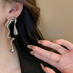 Detail view of large silver liquid metal earrings with irregular pearl accents on model