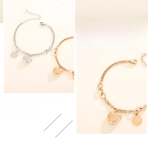 Detail of silver and rose gold heart bracelets with 'Blind for Love' engraved charm