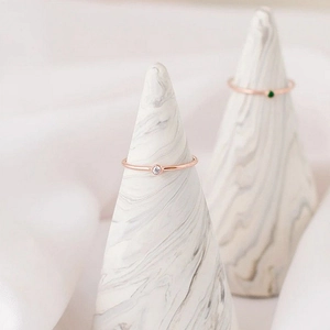 Detailed close-up of minimalist rose gold thin band rings featuring sparkling cubic zircon stones