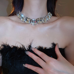 Detailed close-up of a silver choker necklace with square rhinestones worn by a model