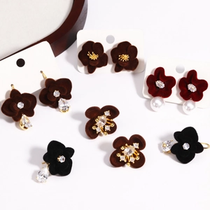 Geometric velvet flower tassel earrings with pearls and gold accents on white base