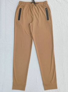 Close-up of khaki jogger pants with elastic waist, drawstring and secure zip pockets