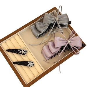 Elegant chiffon bow hair clips with zircon star accents and satin texture on a velvet tray