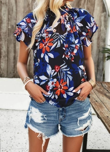 Détail d'une blouse en mousseline à fleurs avec manches volantées et imprimé marine
