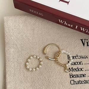 Ensemble bijoux bague perle dorée et manchette d'oreille zircon sur fond élégant