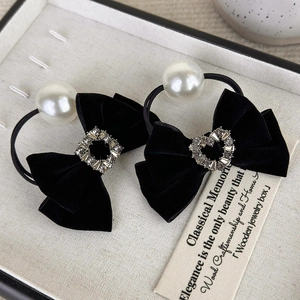 Black velvet bow hair ties with large pearls and rhinestone buckles in a jewelry box