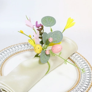 Close-up of Easter napkin ring with speckled eggs, spring flowers, and green satin napkin