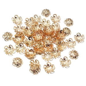 Close-up of bulk golden hollow flower bead caps for DIY jewelry making and craft projects