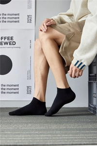 Close-up of black cotton ankle socks for men worn in a casual lifestyle setting