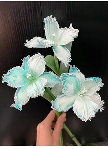 Close-up of artificial mint green tulips with fringed edges against a dark wood background
