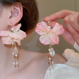 Detail of pink fabric flower earrings with white pearls and crystal fringe tassels