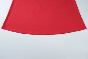 Detailaufnahme des roten Kleidersaums mit hochwertigen Nähten und feiner Stoffbeschaffenheit