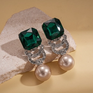 Detail of emerald cut crystal and champagne pearl drop earring on mineral stone base