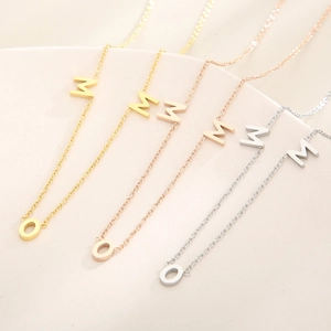Detailed close-up of MOM letter pendants in gold, rose gold, and silver stainless steel