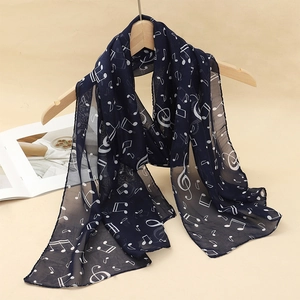 Close-up of navy blue chiffon scarf with white musical note pattern on a hanger