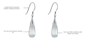 Macro detail of teardrop catseye stone earrings with silver hooks and refined inlay craft