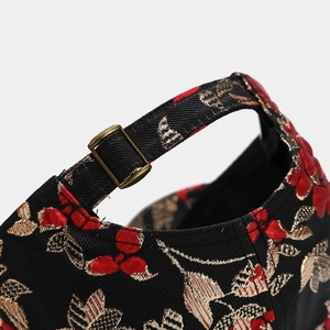 Detailed macro view of the vintage floral embroidery and bronze metal adjustment buckle